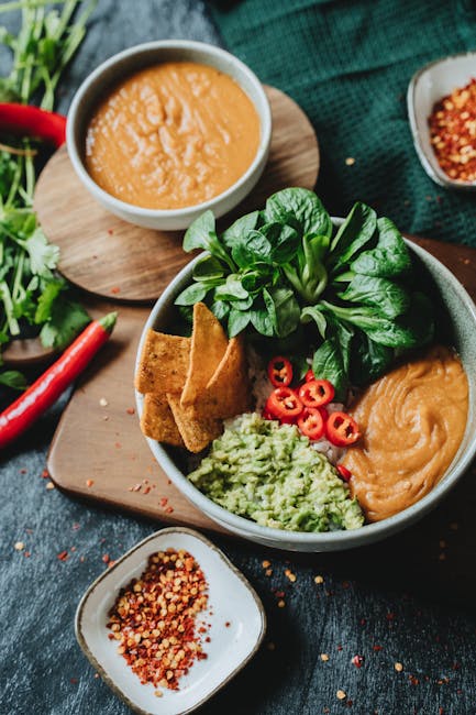 Calculate-impact-of-food-with-LCA-carbon-footprint Colorful vegan nacho bowl with avocado sauce, chili peppers, and fresh greens in a rustic setting. Calculate the environmental impact of your food product with life cycle assessment LCA